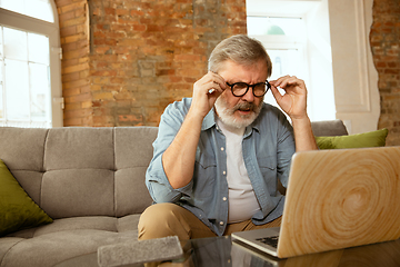 Image showing Senior man working with laptop at home - concept of home studying