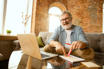 Image showing Senior man working with laptop at home - concept of home studying