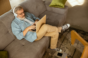 Image showing Senior man working with laptop at home - concept of home studying