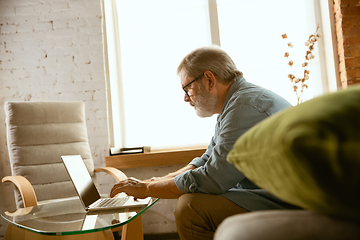 Image showing Senior man working with laptop at home - concept of home studying