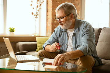 Image showing Senior man working with laptop at home - concept of home studying