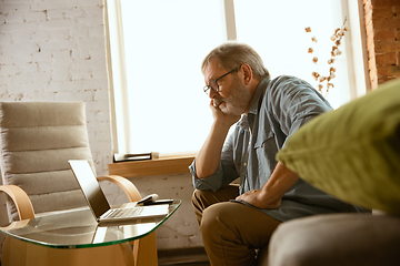 Image showing Senior man working with laptop at home - concept of home studying