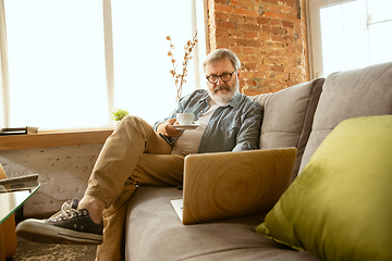 Image showing Senior man working with laptop at home - concept of home studying