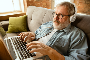 Image showing Senior man working with laptop at home - concept of home studying