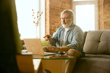 Image showing Senior man working with laptop at home - concept of home studying