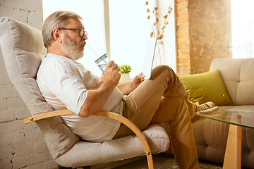 Image showing Senior man working with tablet at home - concept of home studying