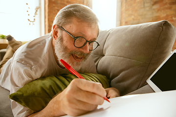 Image showing Senior man working with tablet at home - concept of home studying