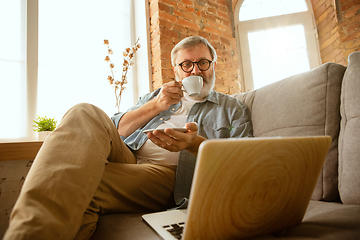 Image showing Senior man working with laptop at home - concept of home studying