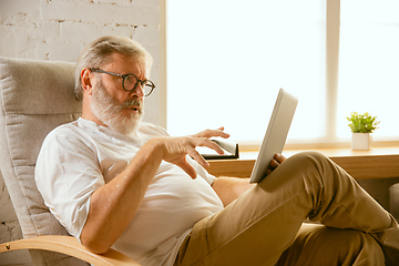 Image showing Senior man working with tablet at home - concept of home studying