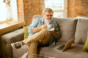 Image showing Senior man working with laptop at home - concept of home studying