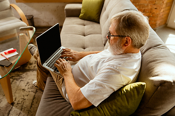 Image showing Senior man working with laptop at home - concept of home studying