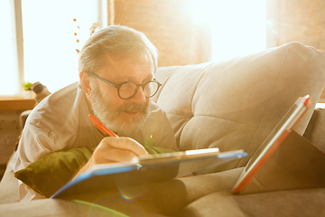 Image showing Senior man working with tablet at home - concept of home studying