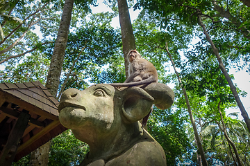 Image showing Monkey on a cow statue in the Monkey Forest, Ubud, Bali, Indones