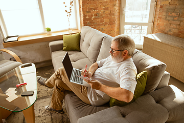 Image showing Senior man working with laptop at home - concept of home studying