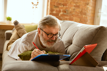 Image showing Senior man working with tablet at home - concept of home studying