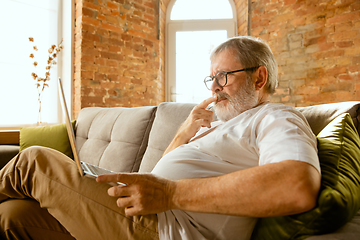 Image showing Senior man working with laptop at home - concept of home studying