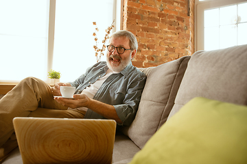 Image showing Senior man working with laptop at home - concept of home studying