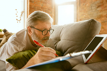 Image showing Senior man working with tablet at home - concept of home studying