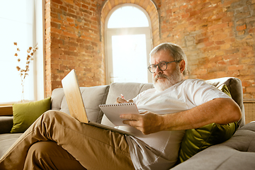 Image showing Senior man working with laptop at home - concept of home studying