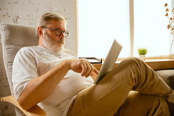 Image showing Senior man working with tablet at home - concept of home studying