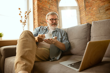 Image showing Senior man working with laptop at home - concept of home studying