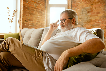 Image showing Senior man working with laptop at home - concept of home studying