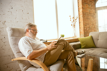 Image showing Senior man working with tablet at home - concept of home studying