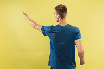 Image showing Caucasian young man\'s half-length portrait on yellow background