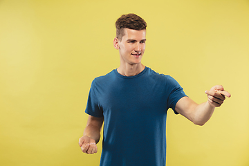 Image showing Caucasian young man\'s half-length portrait on yellow background