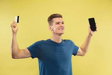 Image showing Caucasian young man\'s half-length portrait on yellow background