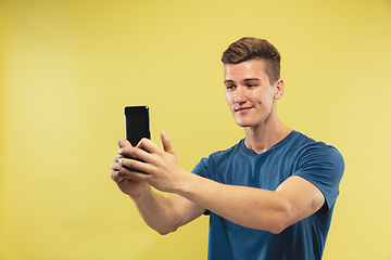 Image showing Caucasian young man\'s half-length portrait on yellow background