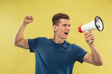 Image showing Caucasian young man\'s half-length portrait on yellow background