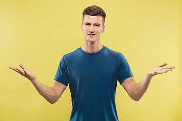 Image showing Caucasian young man\'s half-length portrait on yellow background