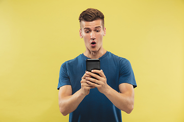 Image showing Caucasian young man\'s half-length portrait on yellow background