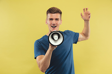 Image showing Caucasian young man\'s half-length portrait on yellow background