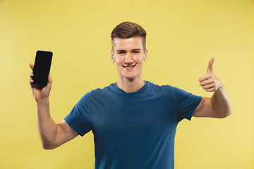 Image showing Caucasian young man\'s half-length portrait on yellow background