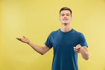 Image showing Caucasian young man\'s half-length portrait on yellow background