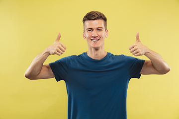 Image showing Caucasian young man\'s half-length portrait on yellow background