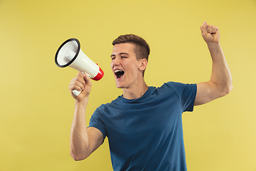 Image showing Caucasian young man\'s half-length portrait on yellow background