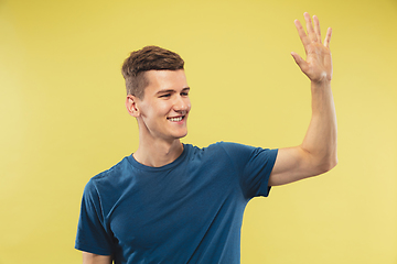 Image showing Caucasian young man\'s half-length portrait on yellow background