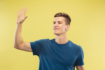 Image showing Caucasian young man\'s half-length portrait on yellow background