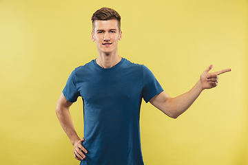 Image showing Caucasian young man\'s half-length portrait on yellow background