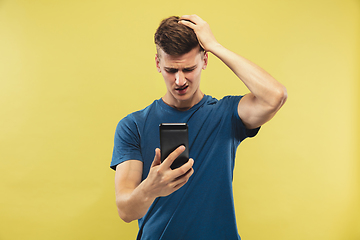 Image showing Caucasian young man\'s half-length portrait on yellow background