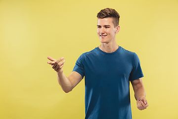 Image showing Caucasian young man\'s half-length portrait on yellow background