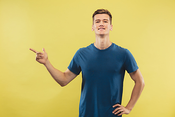 Image showing Caucasian young man\'s half-length portrait on yellow background