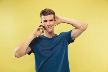 Image showing Caucasian young man\'s half-length portrait on yellow background