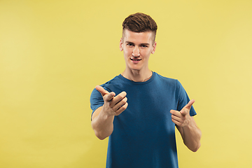 Image showing Caucasian young man\'s half-length portrait on yellow background