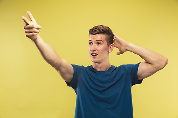 Image showing Caucasian young man\'s half-length portrait on yellow background