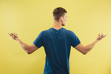 Image showing Caucasian young man\'s half-length portrait on yellow background