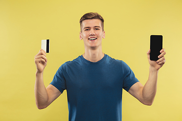 Image showing Caucasian young man\'s half-length portrait on yellow background